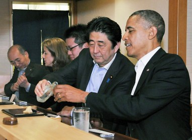 Shinzo y Obama comiendo sushi y bebiendo sake